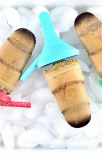 Image of three Keto Coffee Popsicle on ice with multi colored handles.