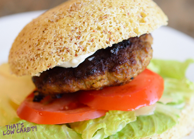 Low Carb Hamburger Buns on a burger with tomato and lettuce.