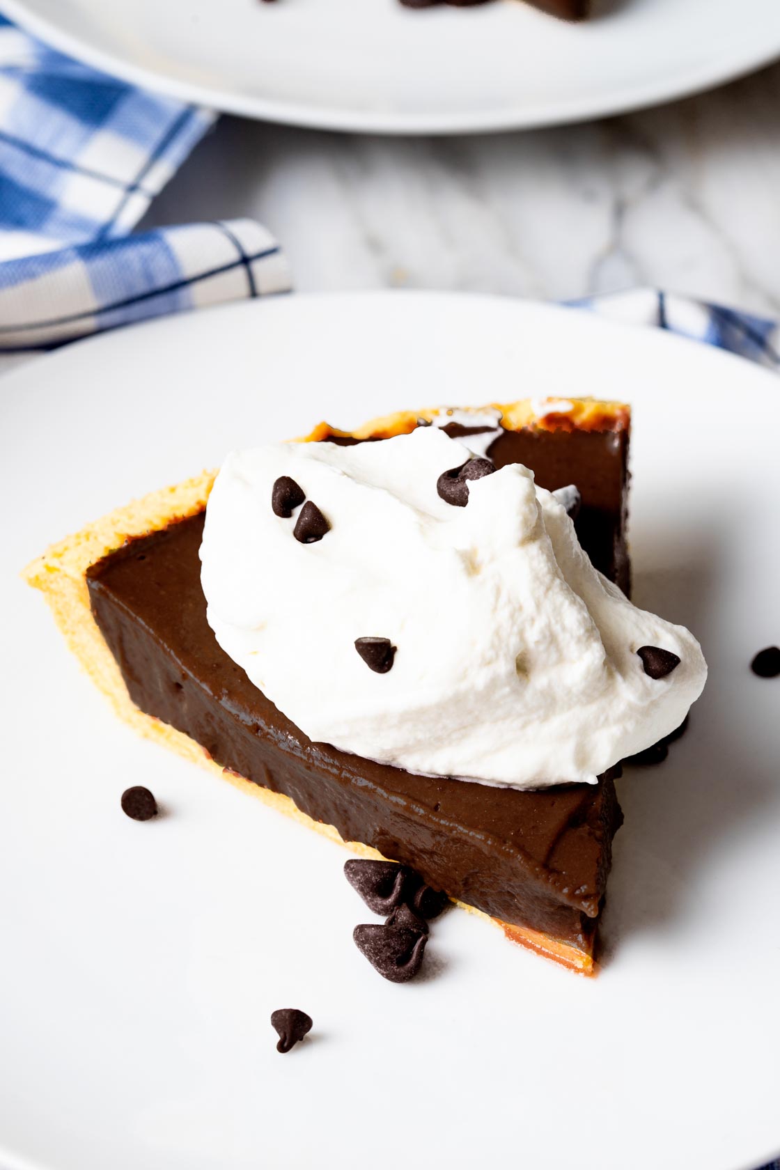 Slice of chocolate pie on plate with whipped cream