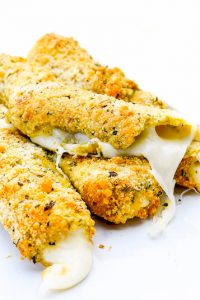 Image of Low Carb, Keto Mozzarella Sticks with one in half and cheese oozing out.