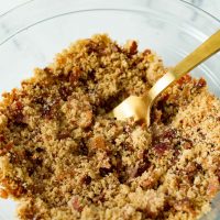 Image of keto low carb breadcrumbs in a glass bowl with a bronze fork sticking out.