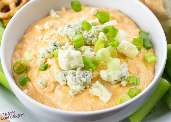 Low Carb Buffalo Chicken Dip in a bowl with blue cheese crumbles and green onion on top.