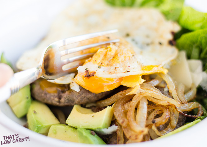 Healthy Big Mac Low Carb Salad with avocado, onion, and egg being cut into by a fork.