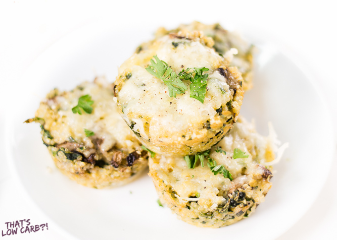 Low Carb Egg Muffins with bacon stacked on a white plate with green garnish.