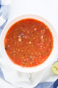 Overhead shot of Low Carb Homemade Salsa in a white bowl with a spoonful being lifted out.