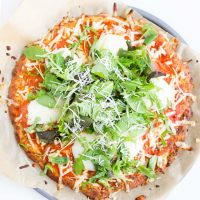 Image of pizza made with Easy Keto Pizza Dough Crust with spinach and mozzarella on top.