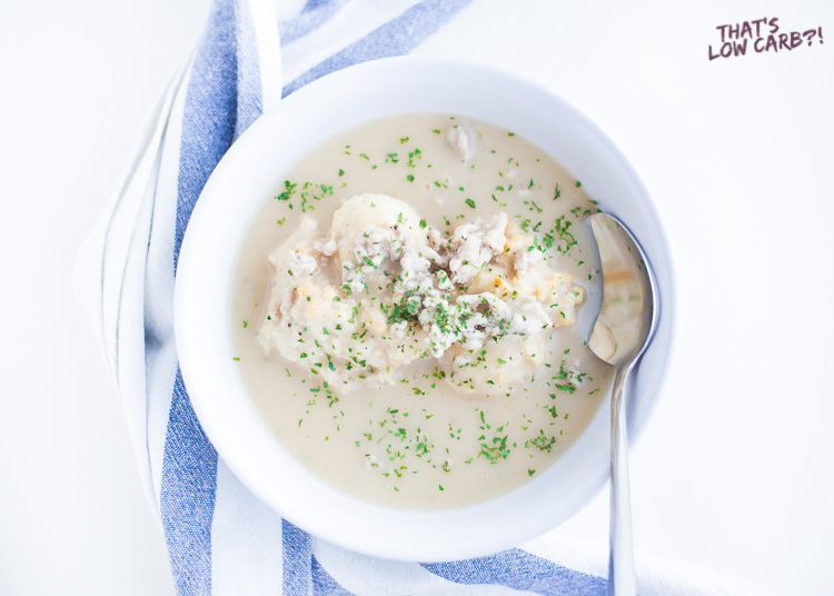 Overhead shot of Low Carb Keto Biscuits and Gravy in a white bowl with green garnish.
