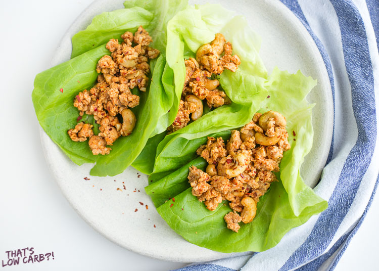 Overhead shot of Low Carb Cashew Chicken Lettuce Wraps opened up on a white plate.
