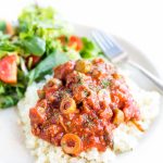 Image of low carb mexican picadillo on bed of rice on white plate with side salad.