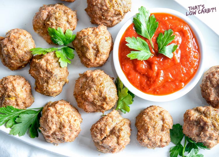 Image of Easy Keto Meatballs No Carb Meatballs on a white plate with a small bowl of red dipping sauce.