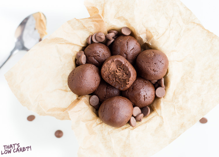 Overhead shot of Keto Peanut Butter Chocolate Bombs in a bowl with parchment paper with chocolate chips on top.