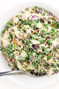 Image of Low Carb Keto Coleslaw in a white bowl with a silver spoon.
