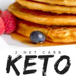 PINTEREST IMAGE with words "2 net carb Keto Cream Cheese Pancakes" with image of Keto Cream Cheese Pancakes stacked with syrup and fruit and whip cream.