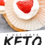 PINTEREST IMAGE with words "1 net carb keto cheesecake fat bombs" with image of keto cheesecake fat bomb being held in an opened muffin paper and a strawberry on top.