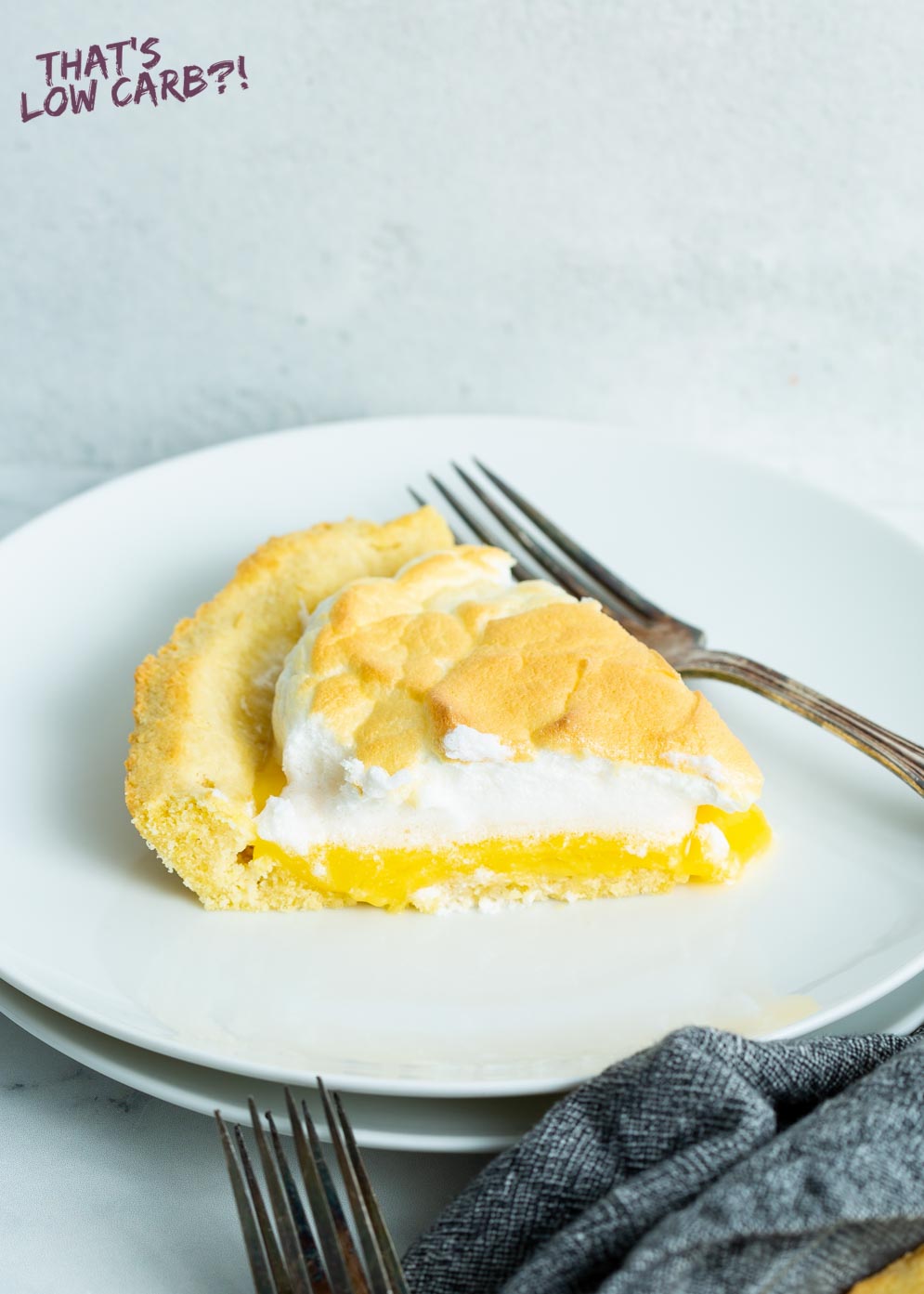 Slice of Sugar-Free Lemon Meringue Pie on small white plate with fork