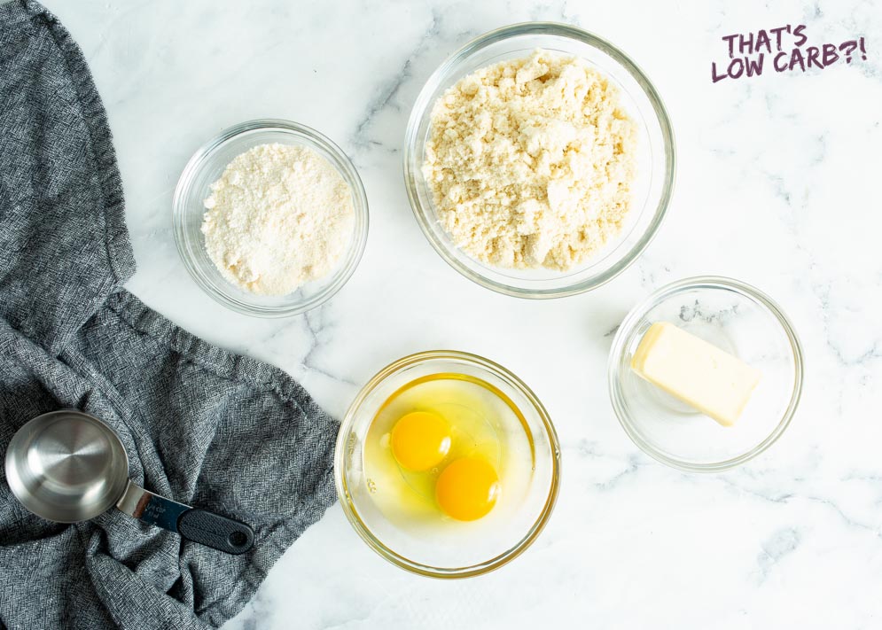 ingredients for the low carb pie crust displayed out in bowls with cloth and measuring cup to the left
