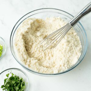 Cheddar Biscuits ingredients being mixed with a whisk in a glass bowl