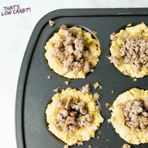 Sausage piled into the center of dough in a muffin tin