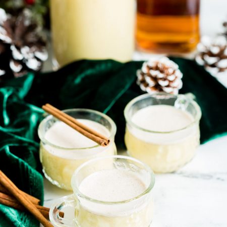 three glasses of eggnog on a white backdrop
